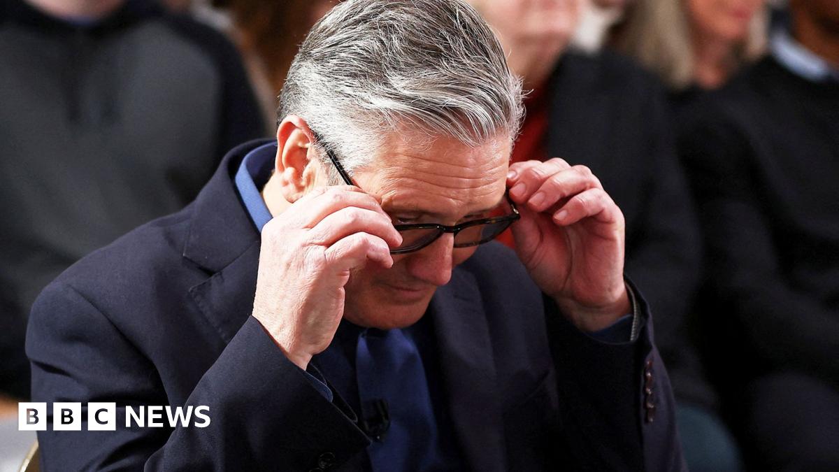 Close up of Keir Starmer adjusting his glasses looking down at the ground
