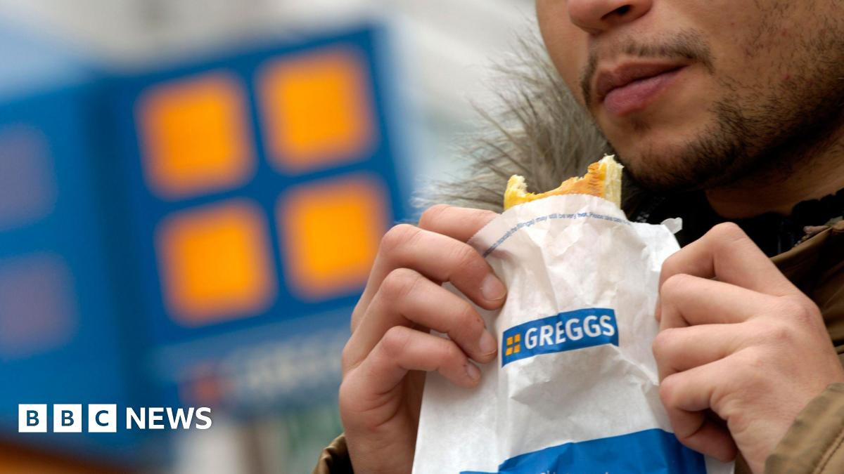 A man eating a Greggs pasty