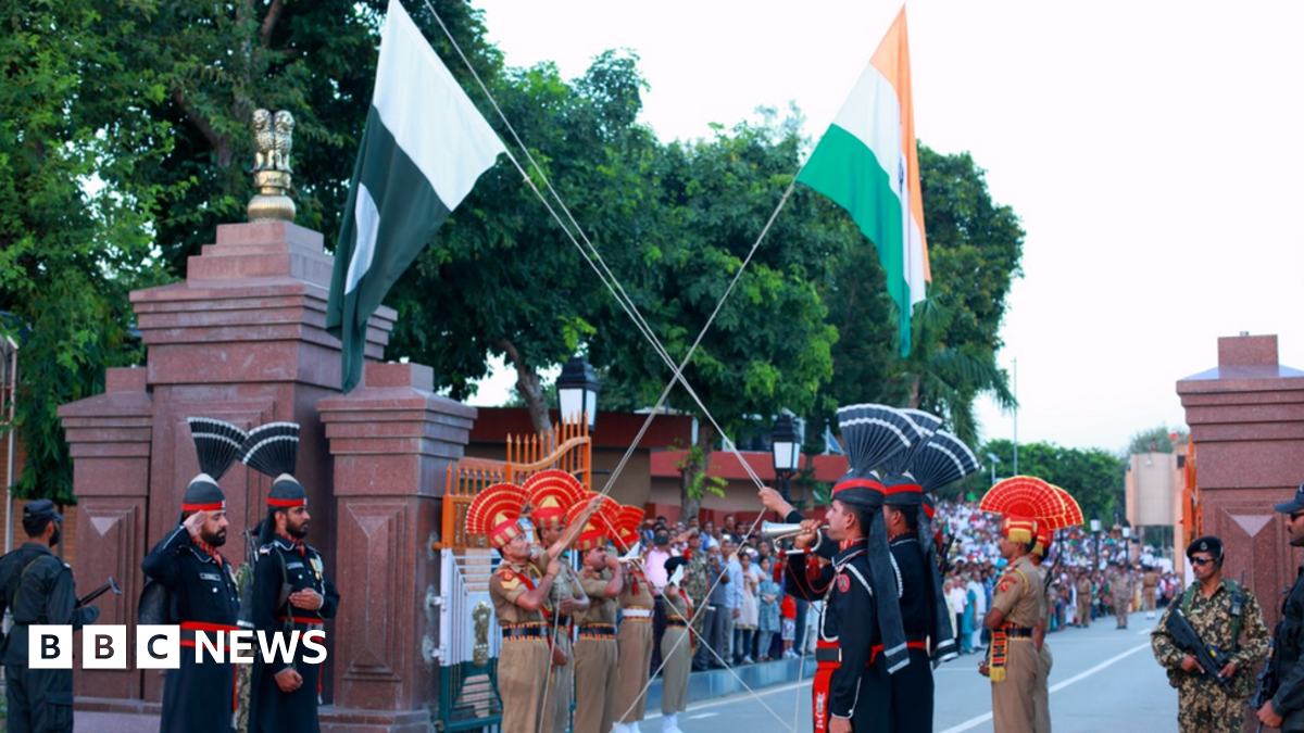 Indian and Pakistani troops lower flags together in a ceremony at the Wagah border crossing near Amritsar