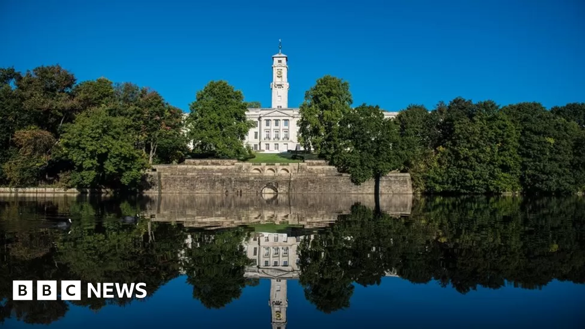 An image of the University of Nottingham surrounded by trees and a lake
