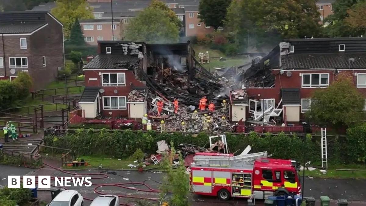 Firefighters on site at the explosion. The houses in the centre have been ripped apart with debris on the ground.