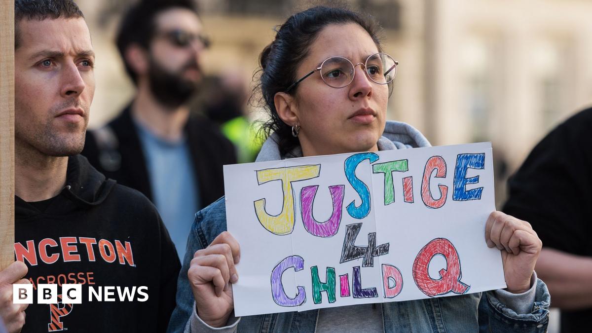 A protester holds a placard saying 'justice 4 child Q' with other activists in shot, outside BBC Broadcasting House in London in March 2022