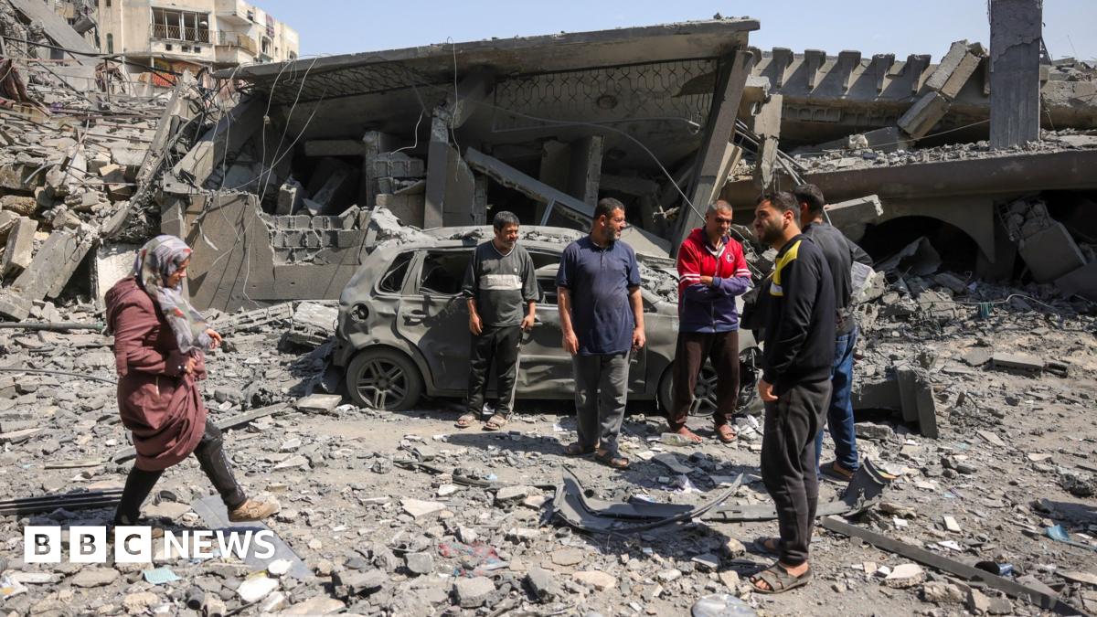 People walk amid the rubble of a building destroyed in an overnight Israeli strike in Jabalia on 18 March.
