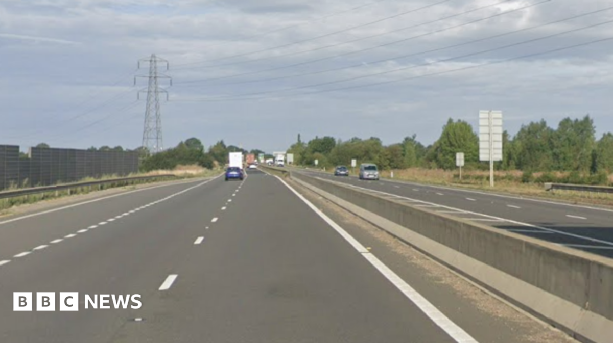 A dual carriageway has a few cars driving on either side of the road. There is a barrier which runs in between the roads.