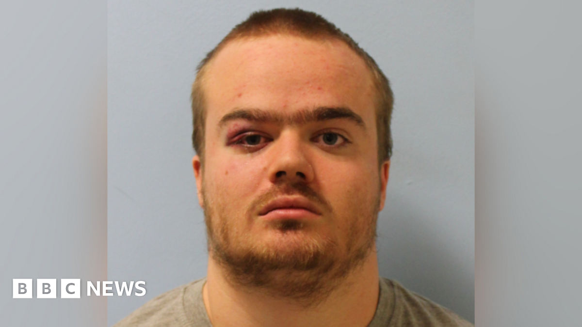 A mugshot of Jonty Bravery, who is wearing a grey shirt. He is staring at the camera and has a beard and short, blonde hair. 