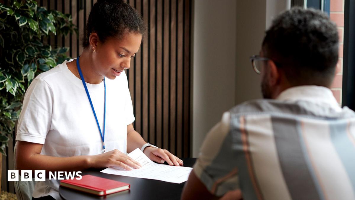 A young woman in a modern office at a table with a co-worker