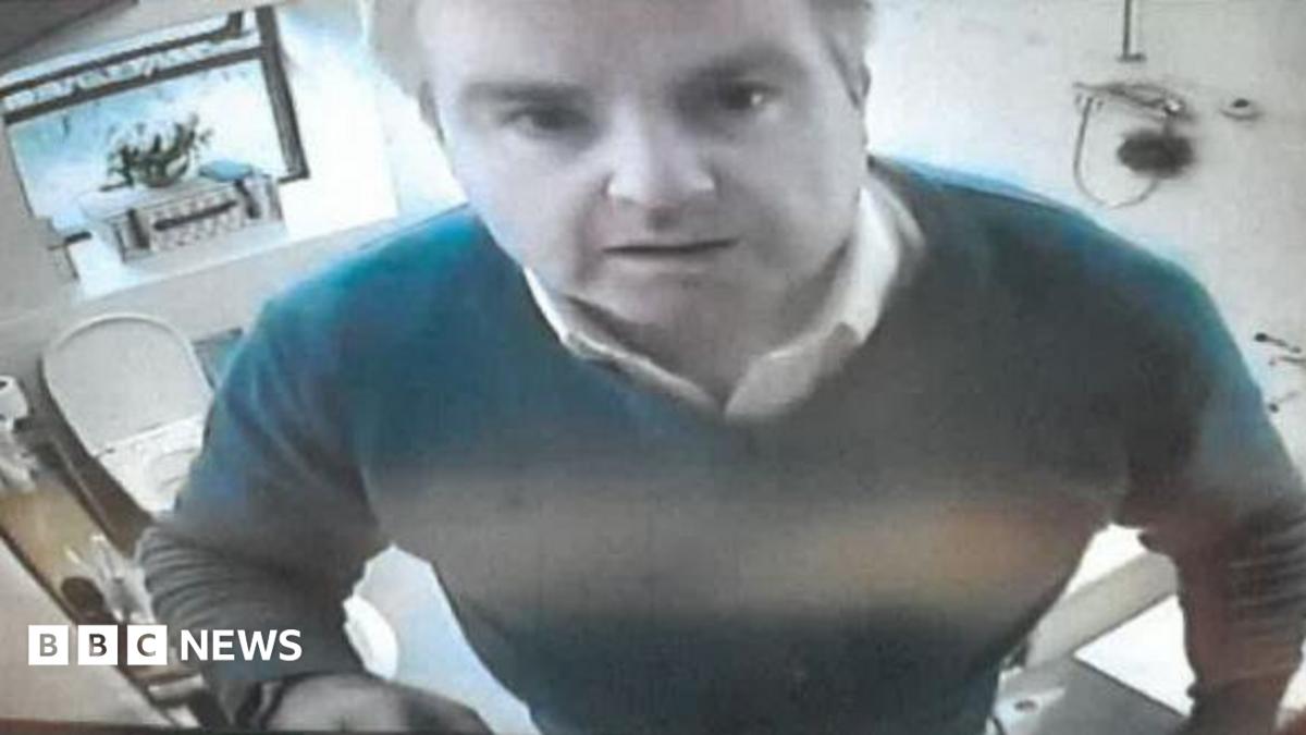 Robert Holden looking into a camera in his bathroom