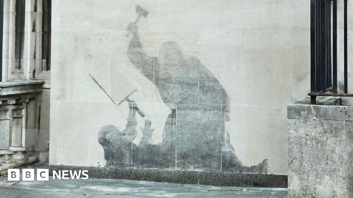Banksy mural of a judge attacking a protestor with a gavel. The painting has been washed away, so the details are not visible, leaving a grey shadowy silhouette.