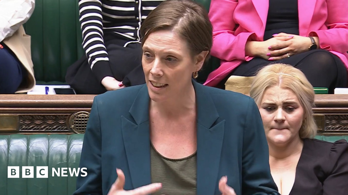 Safeguarding Minister Jess Phillips in the House of Commons. She wears a teal jacket and a khaki green top.