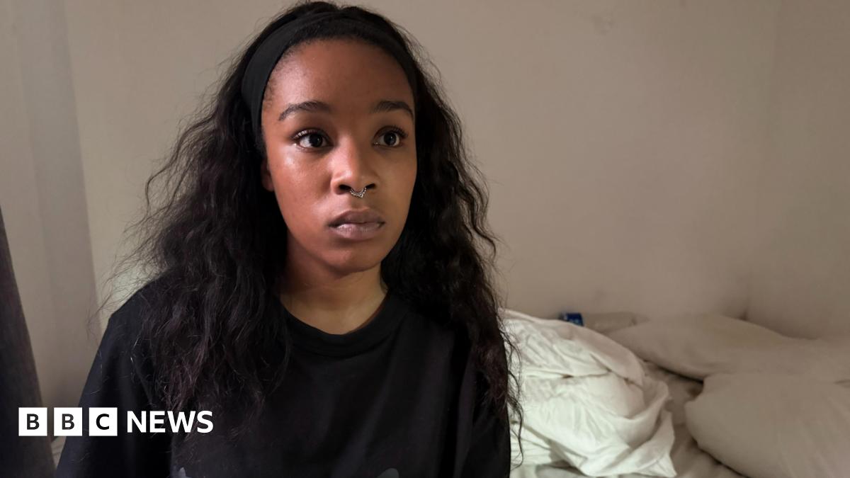 Isabel Rose is seen wearing a black top and a small nose ring, sits facing the camera indoors.