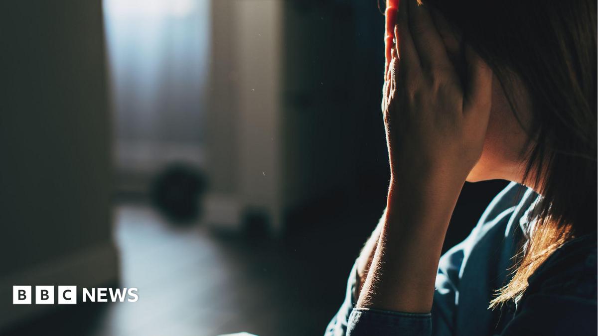 A woman is upset and holds her head in her hands