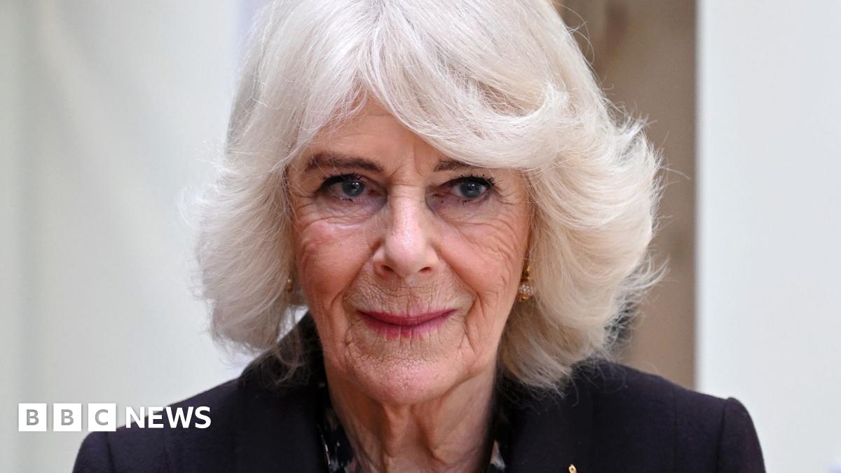 Queen Camilla looks away from camera while wearing a black suit jacket, pictured in London in February.