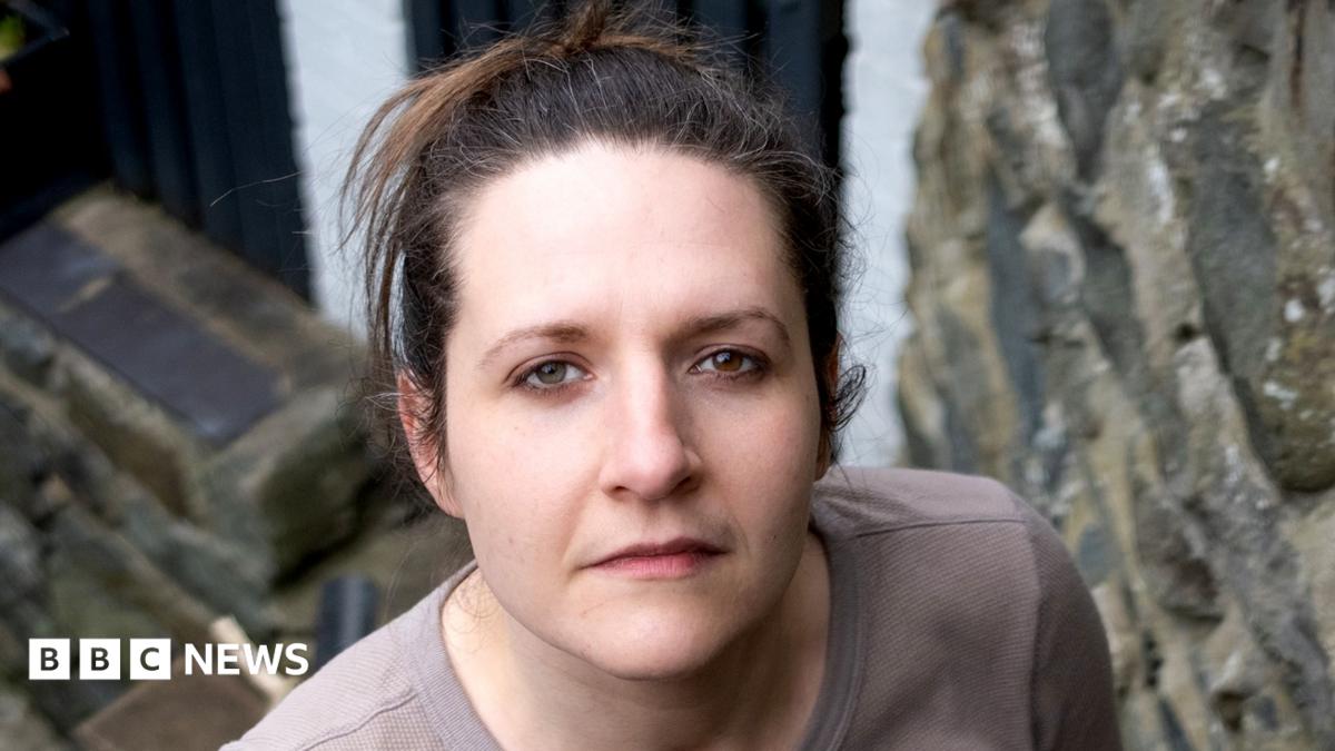 Ruth has dark hair and is looking directly at the camera.