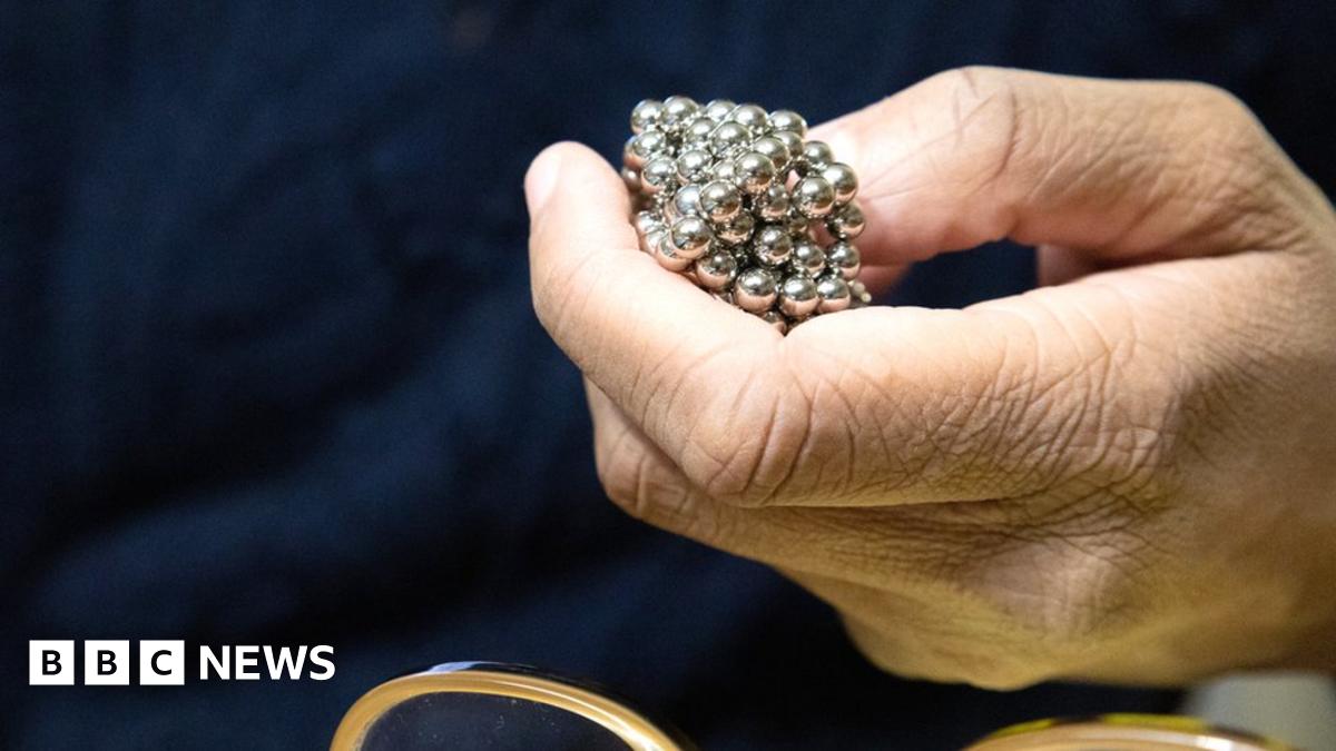 Hand holding magnetic metal balls