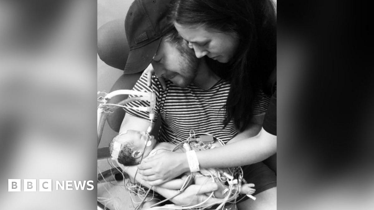 Quinn Parker's parents holding the baby. It's a black and white picture.