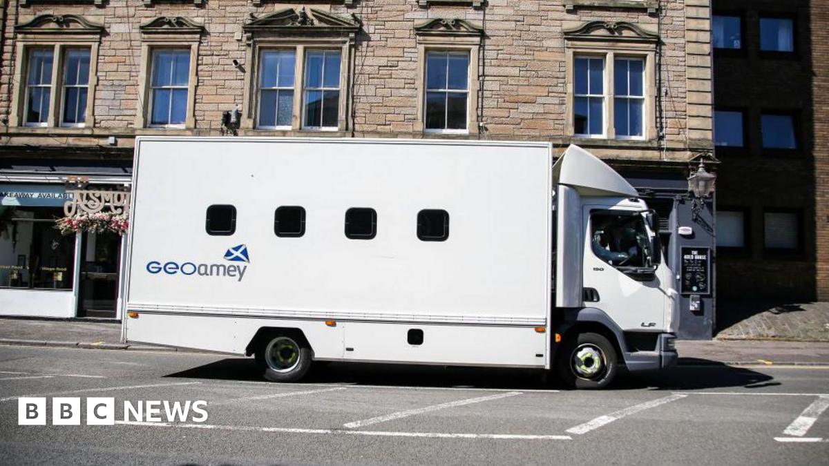 A white GeoAmey prison van driving past St Leonard's in Edinburgh. 