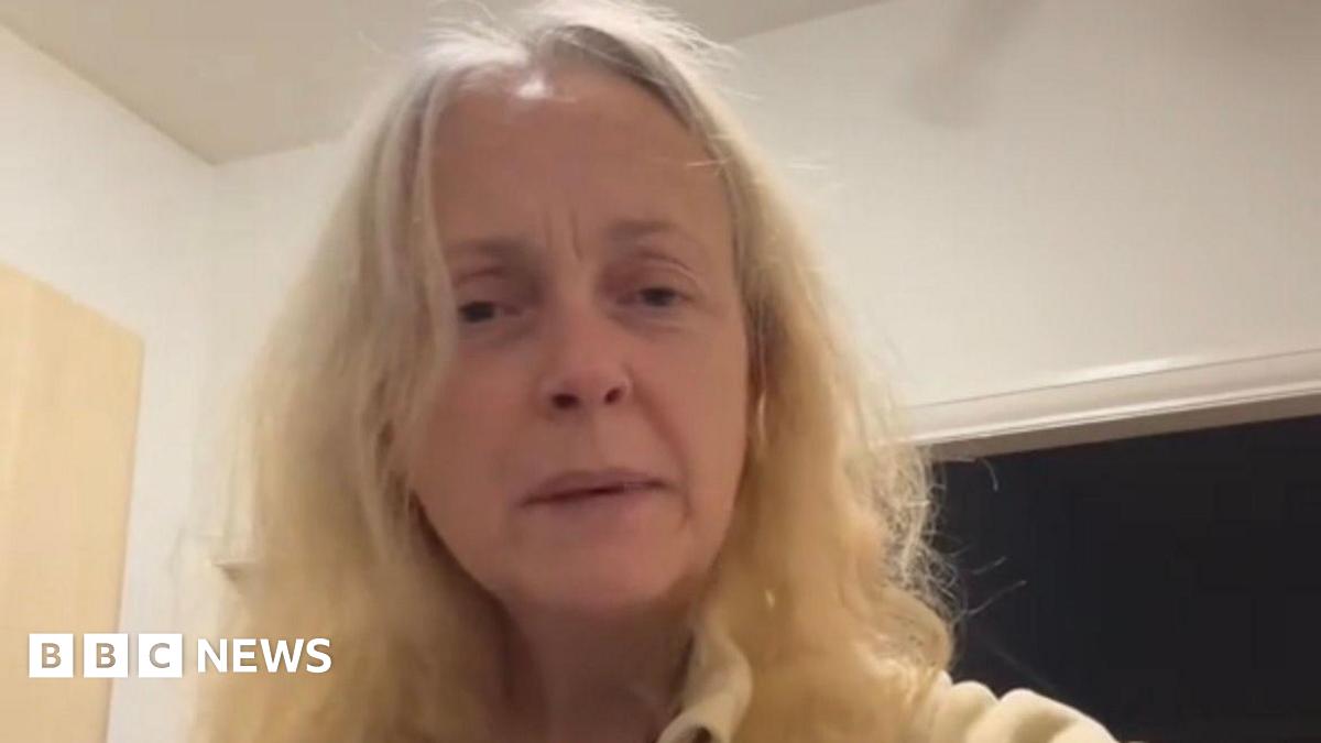 A woman in her 50s with blonde hair looks at the camera