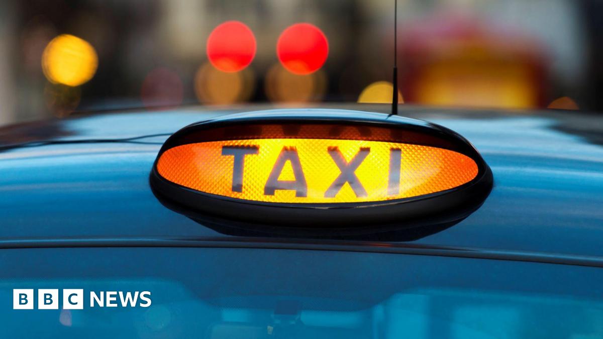 A close-up photo of a black and yellow taxi sign