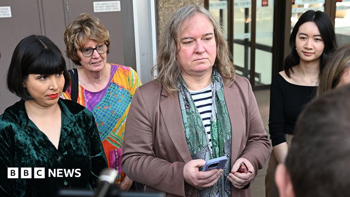 Roxanne Tickle (centre) looks on as she is surrounded by people while speaking to press outside the Federal Court of Australia in Sydney on 23 August.