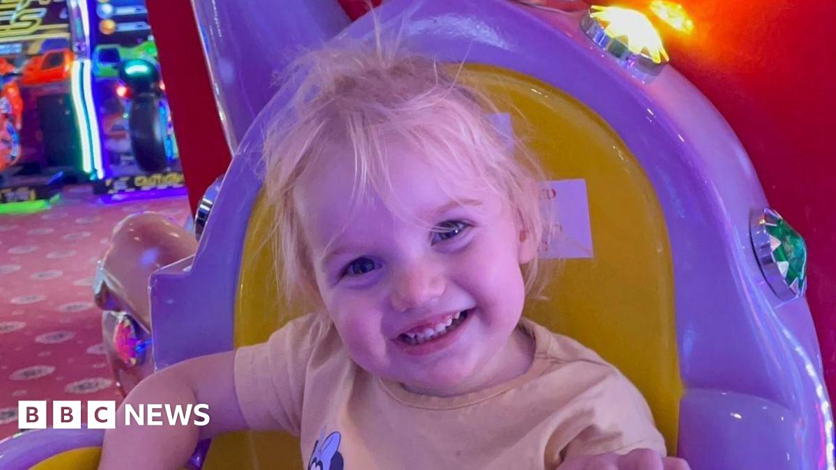 A close-up of Isabella Jonas-Wheildon sitting in an amusement ride while smiling into the camera