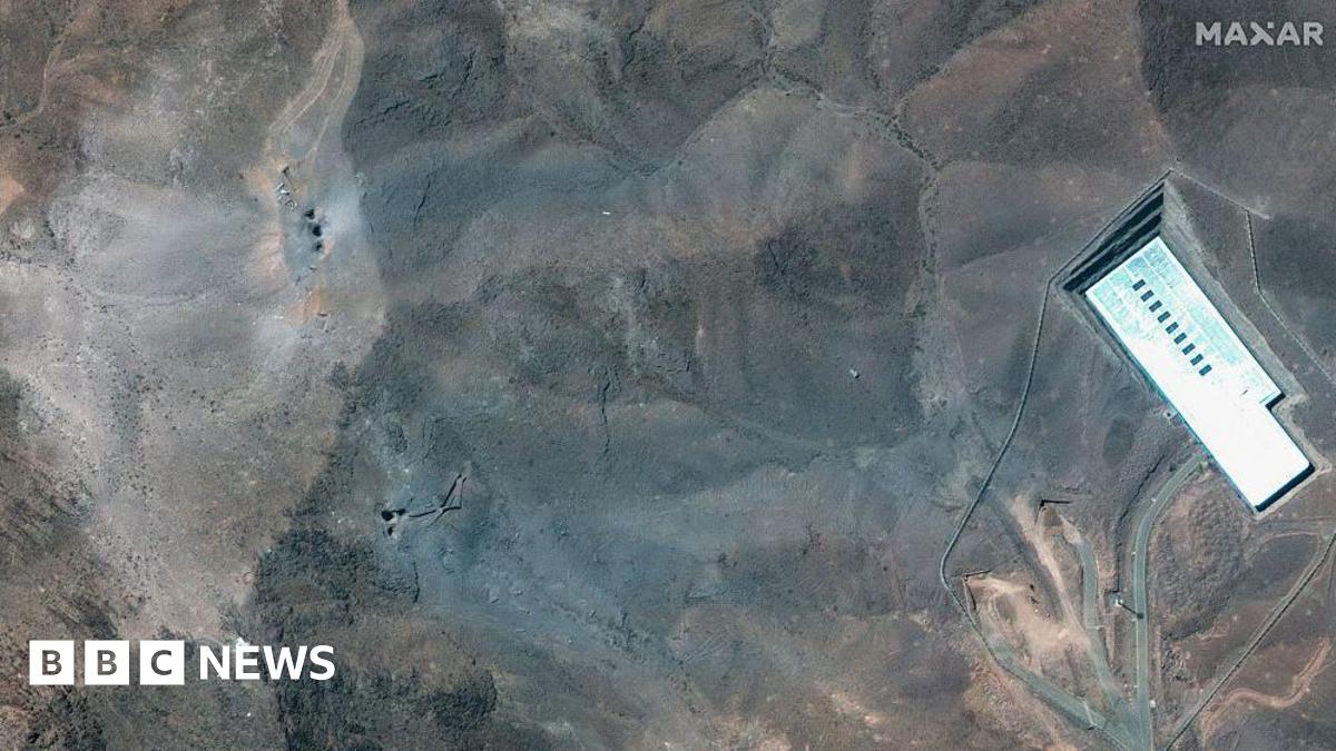 Maxar Satellite Imagery shows the ridge above the Fordo complex post-strike. Multiple impact craters and a wide grey-blue ash layer are visible across the ridge, suggesting direct hits to the overburden covering the underground facility. 