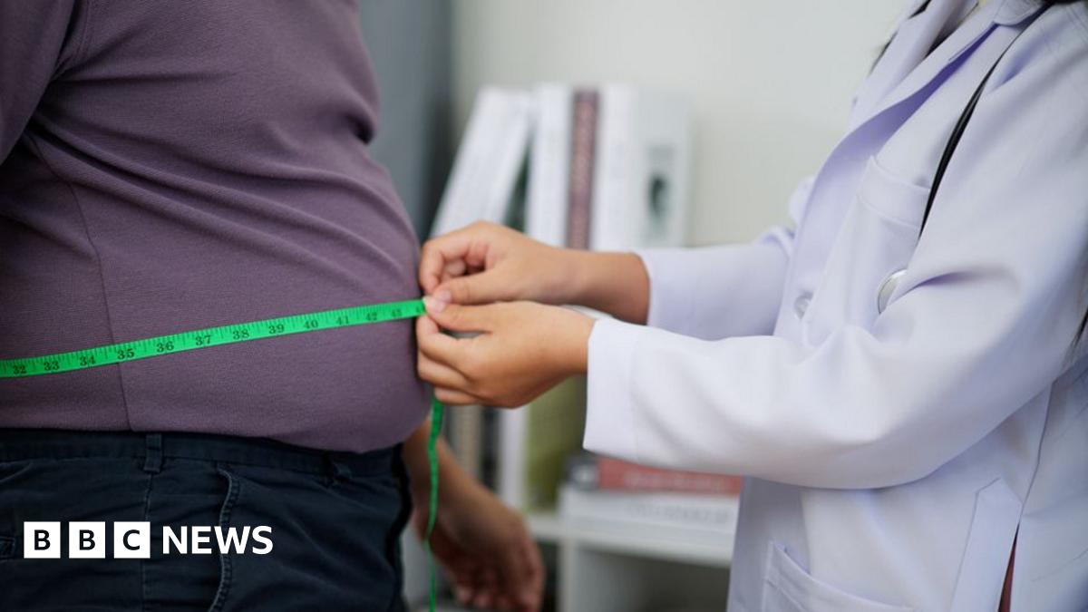 Clinician measuring the waist of an overweight man