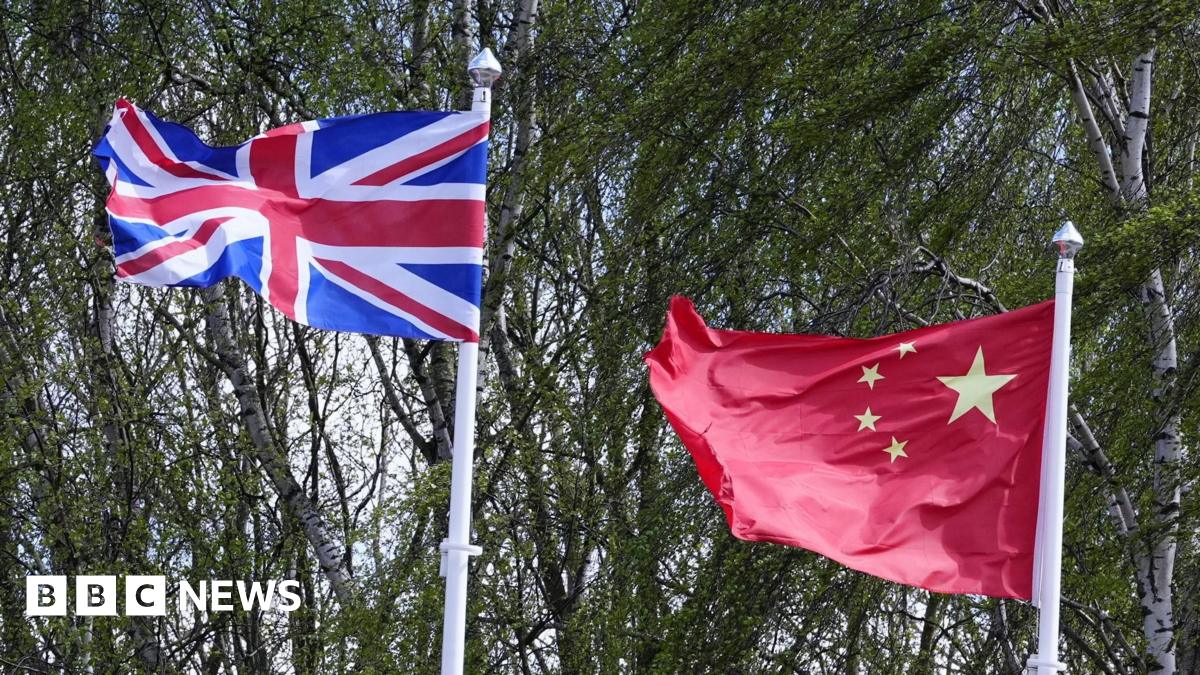 The Union Flag and Chinese Flag on flagpoles in front of trees
