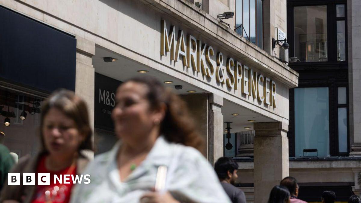 A Marks & Spencer shop on a busy high street in summer