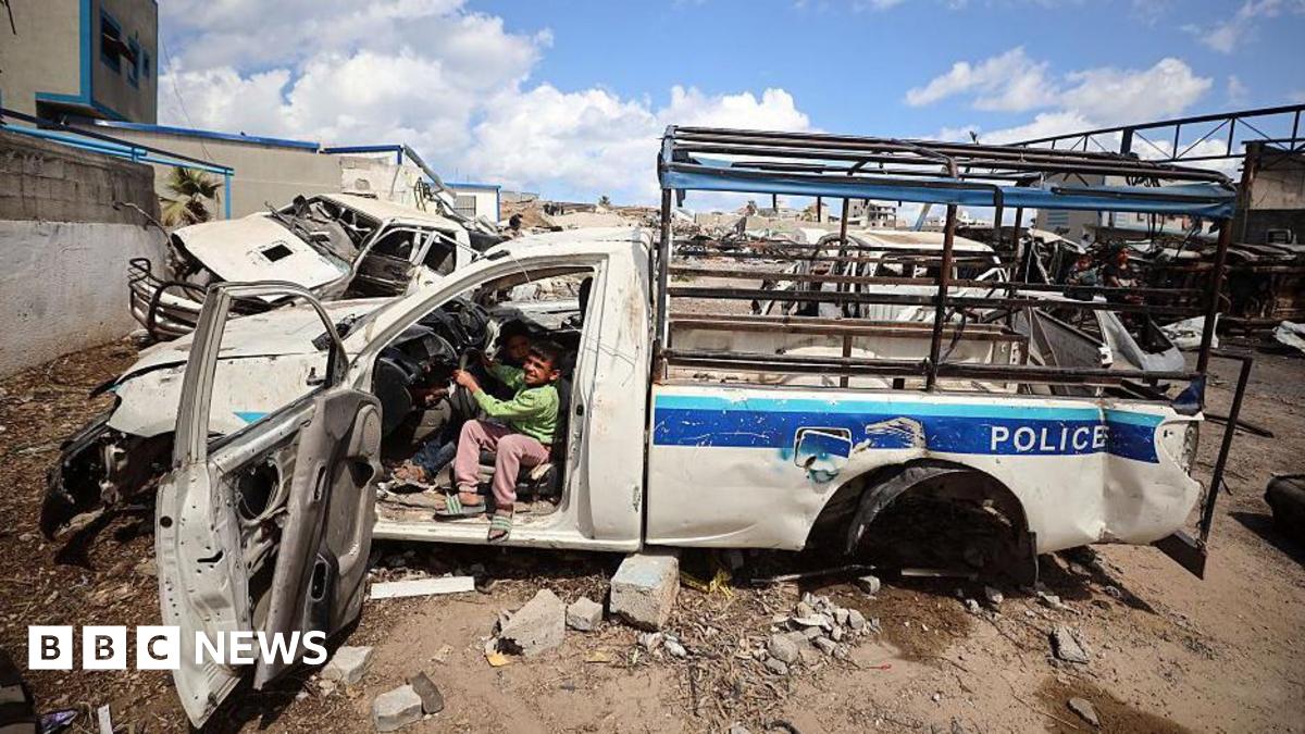 Displaced Palestinian children play inside a destroyed police car in a temporary camp within the site of the Arafat Police Academy, in the destroyed police camp affiliated with Hamas, in Gaza City (10 April 2025)