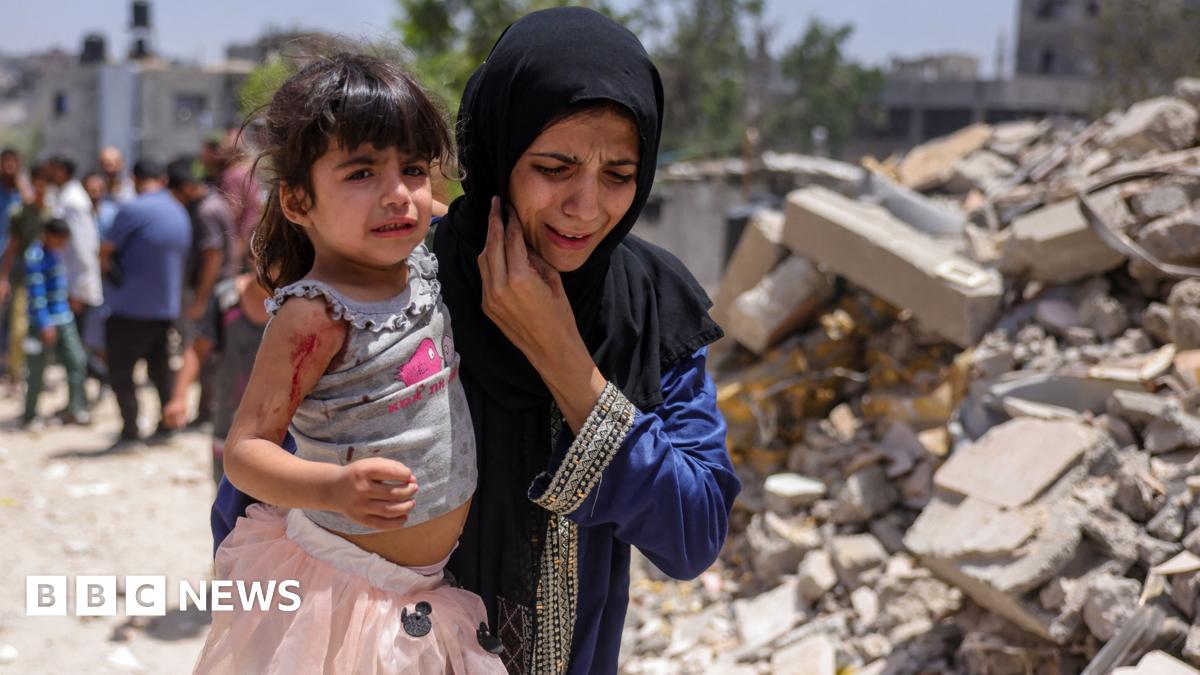 A Palestinian woman carries a girl wounded in an Israeli strike in the Saftawi neighbourhood west of Jabalia in the northern Gaza Strip on May 27, 2025