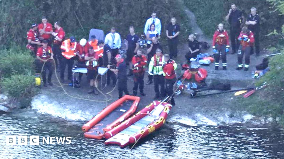 Search and rescue teams at the side of a pond