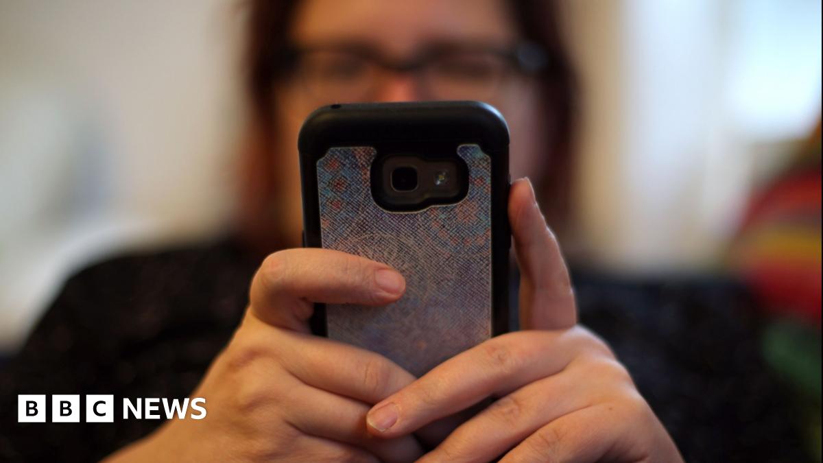 Woman holds up smartphone