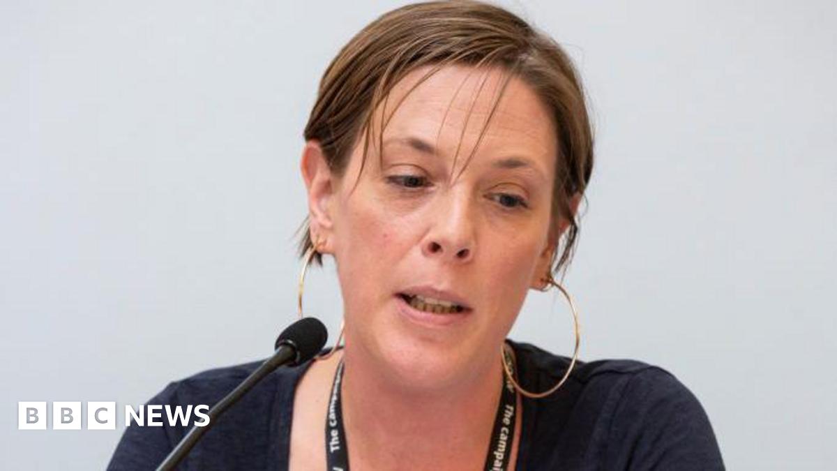 Jess Phillips has short brown hair tucked behind her ears. She is wearing a blue top and is looking downwards in the image.