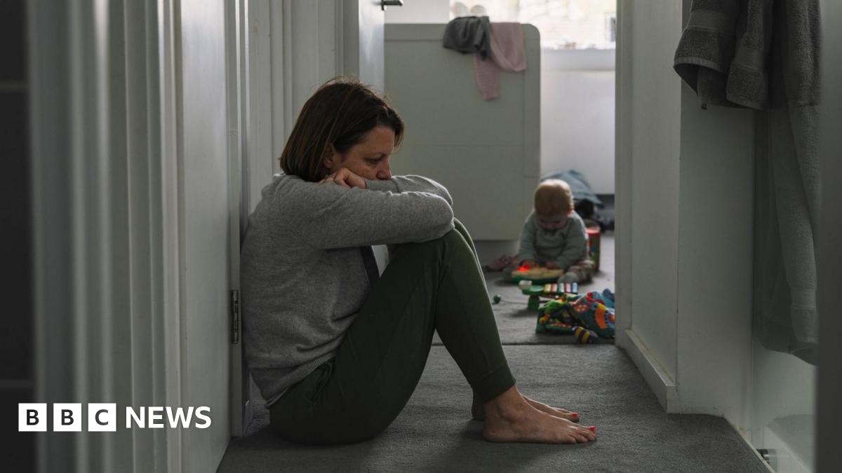Generic picture of a mother sitting on the floor with her baby in the background
