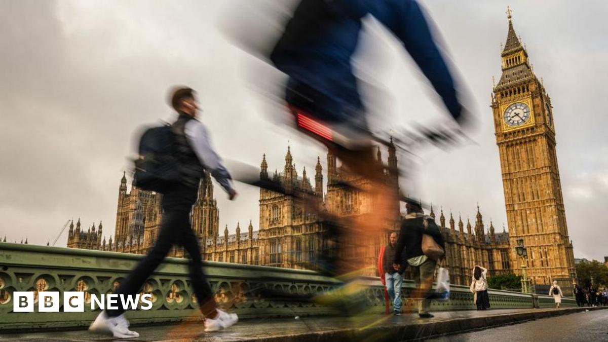 Blurred images of commuters walking in front of the Houses of Parliament