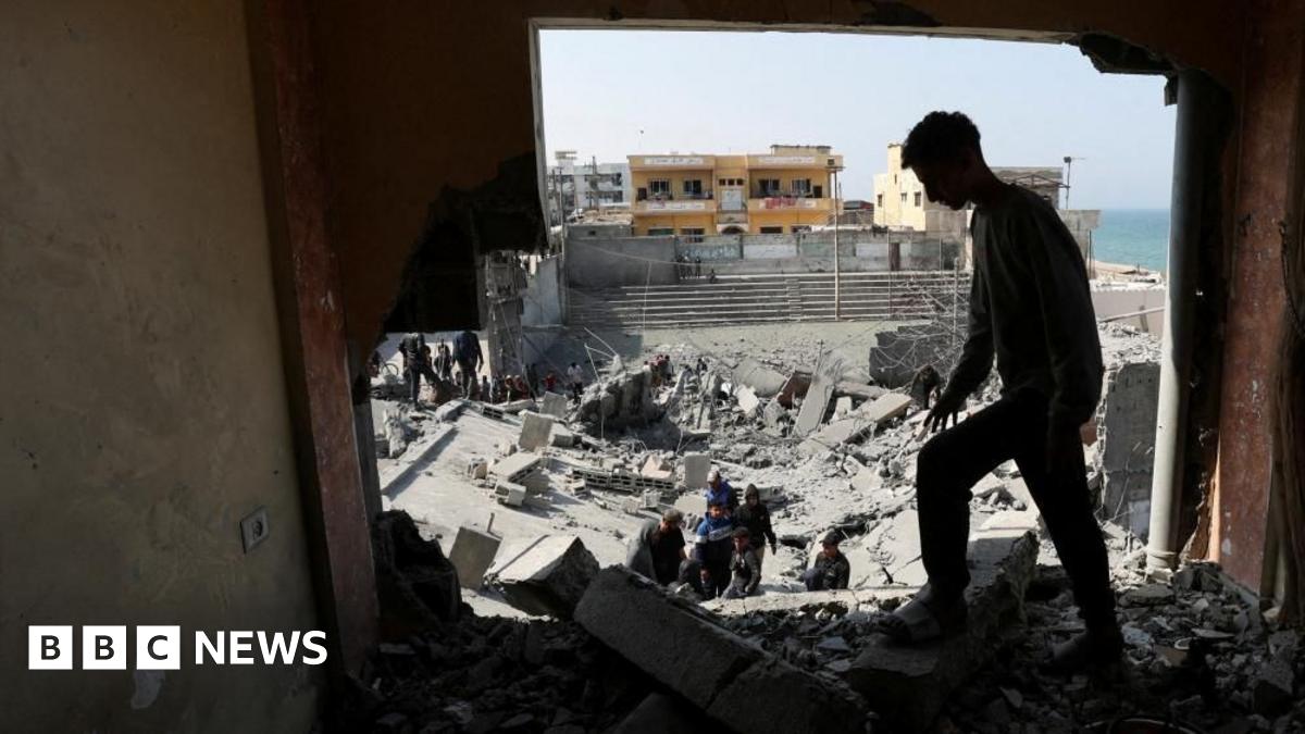 Palestinians inspect the site of an Israeli strike on a residential building, in Deir al-Balah in central Gaza.
