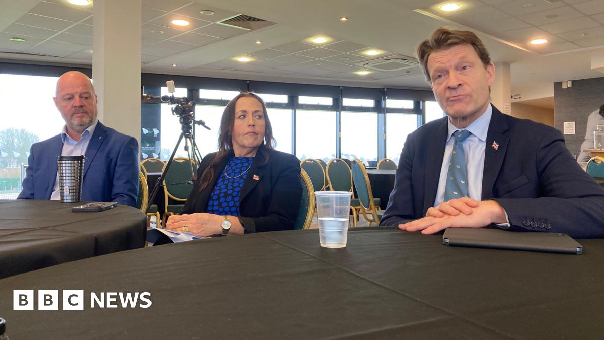 Three people sat behind a table at a press conference, including the leader of Worcestershire County Council, Cllr Jo Monk, and Richard Tice, deputy Reform UK leader.