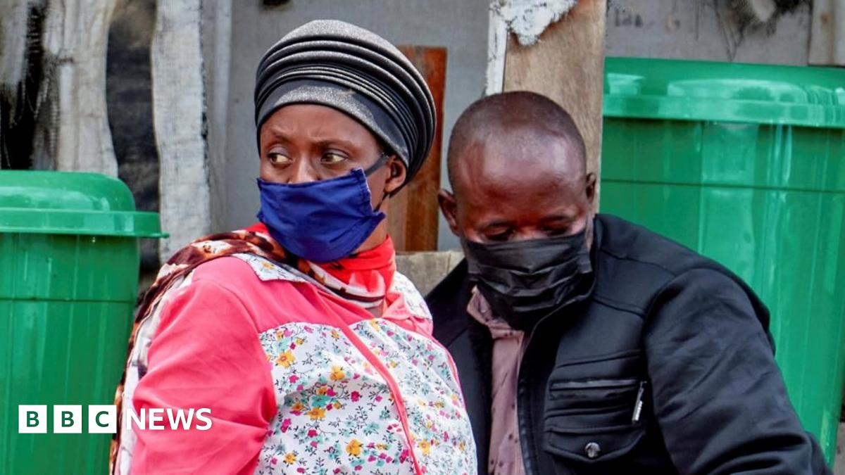 A woman and a man - both wearing face masks - mourn the death of an Ebola victim in Bunia, in the eastern Democratic