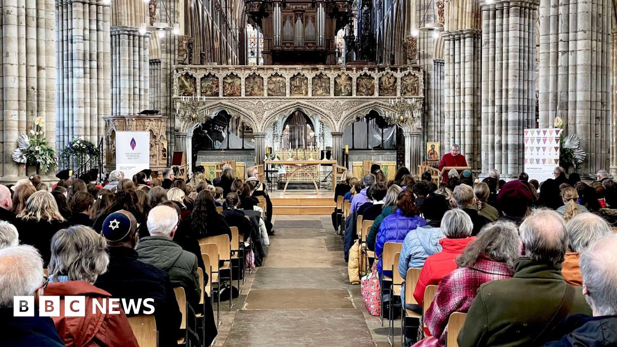 Rows of people sitting down and facing the front of a church. 