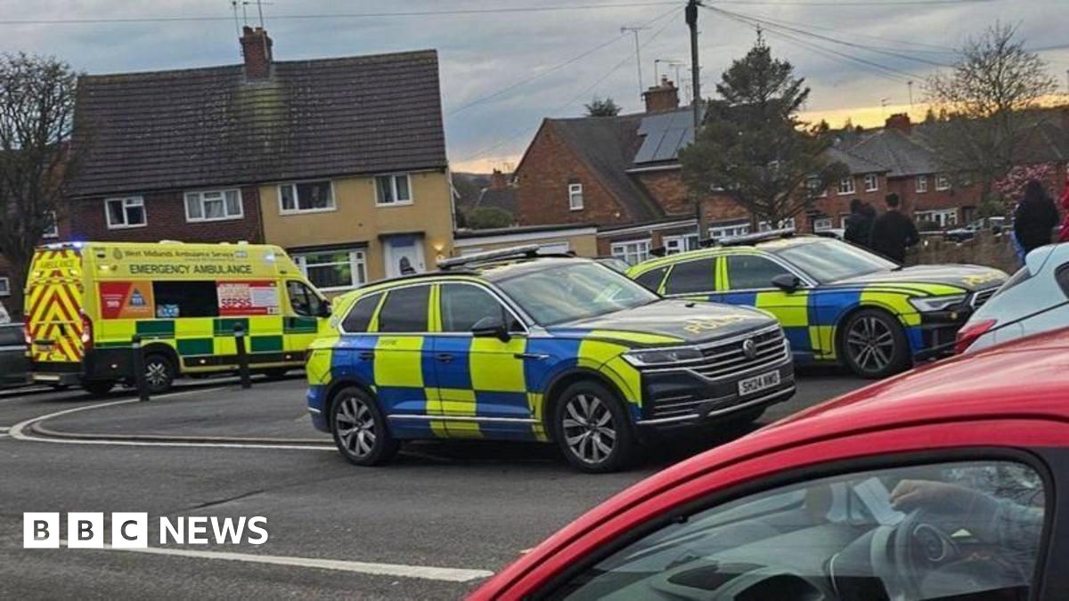 Two police cars and an ambulance parked on a residential street 