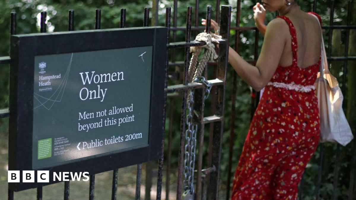 The sign indicating the 'Women Only' swimming pond is seen attached to gates on Hampstead Heath