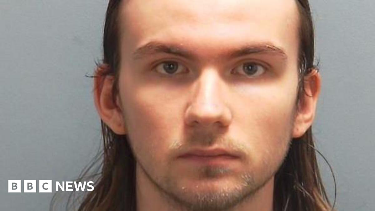 Oliver Smith has long, brown hair and stubble, in a police custody photo.