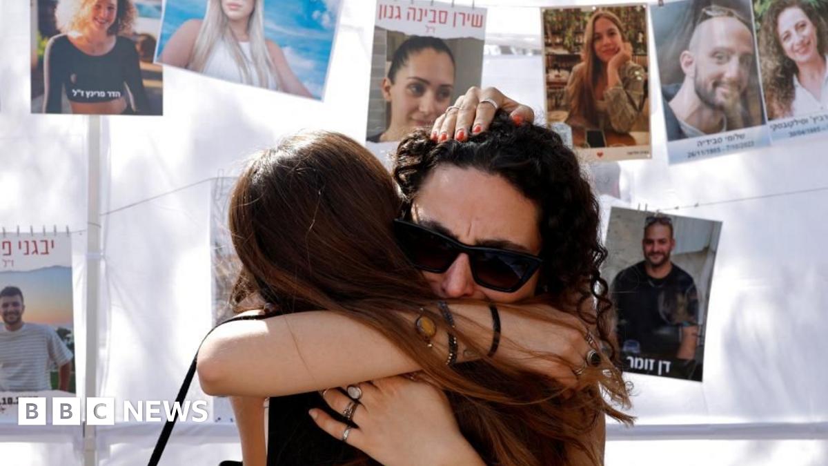 Two women hug in grief at the site of the Nova festival attack, on 7 October 2025
