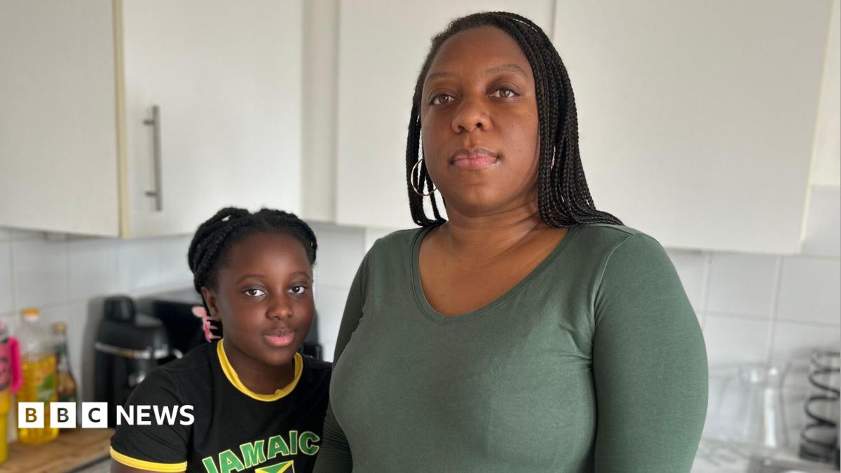 A nine year old girl wearing a black print t-shirt stands beside her mother who is wearing a long sleeved green t-shirt