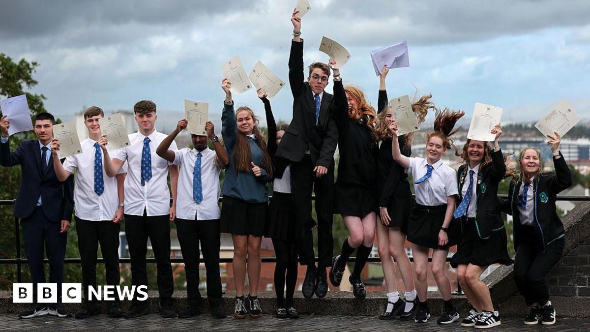 Students smiling and jumping holding their a-level results 