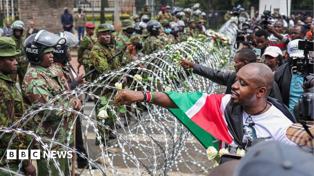 Families lay flowers on barbed wire barricade on anniversary of deadly Kenya protests
