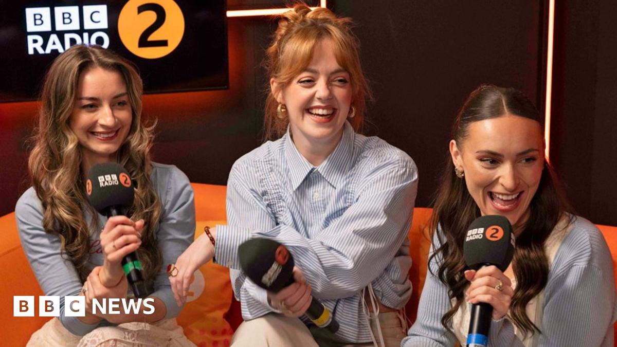 Remember Monday's members smiling and speaking with microphones in the BBC Radio 2 studio