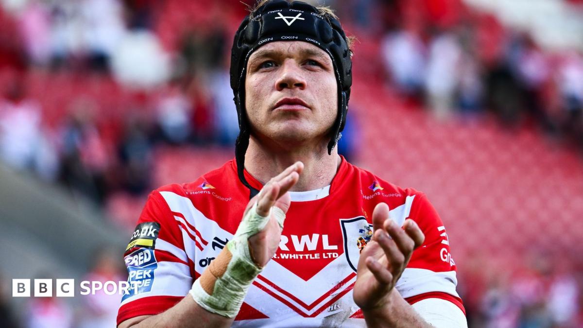Jonny Lomax, wearing a trademark scrum cap with the chin strap undone, applauds the St Helens fans after a match