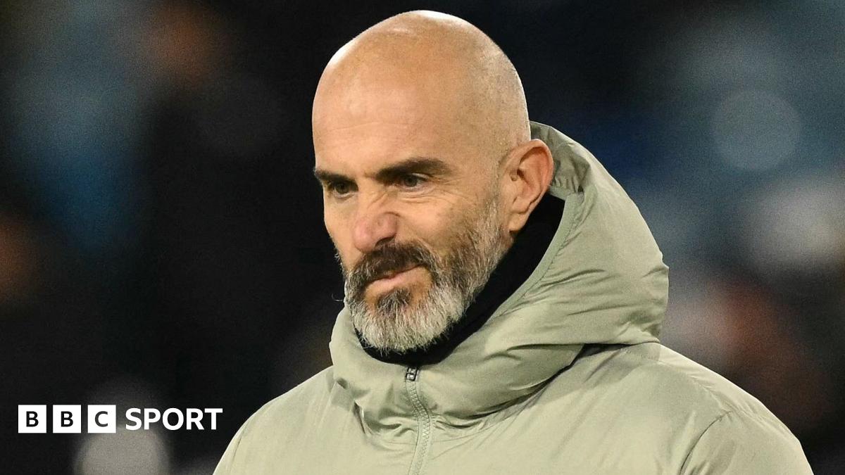 Premier League manager speaking at a pre-match news conference with club backdrop