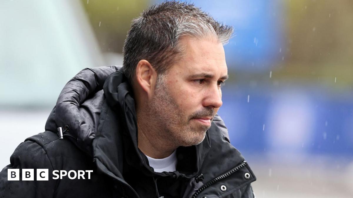 Championship football action under the floodlights with players challenging for the ball